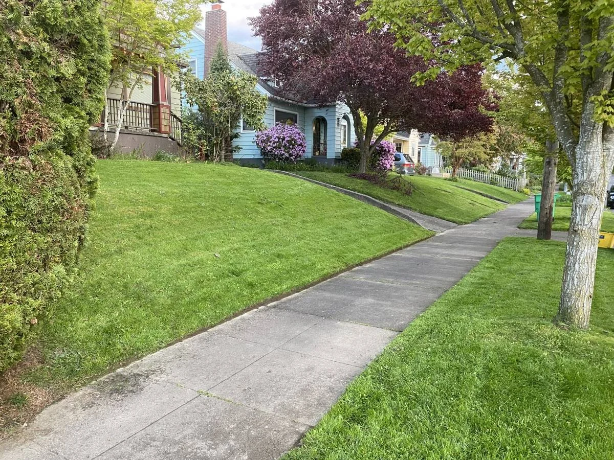 Portland craftsman blue house with freshly mowed and edged front lawn