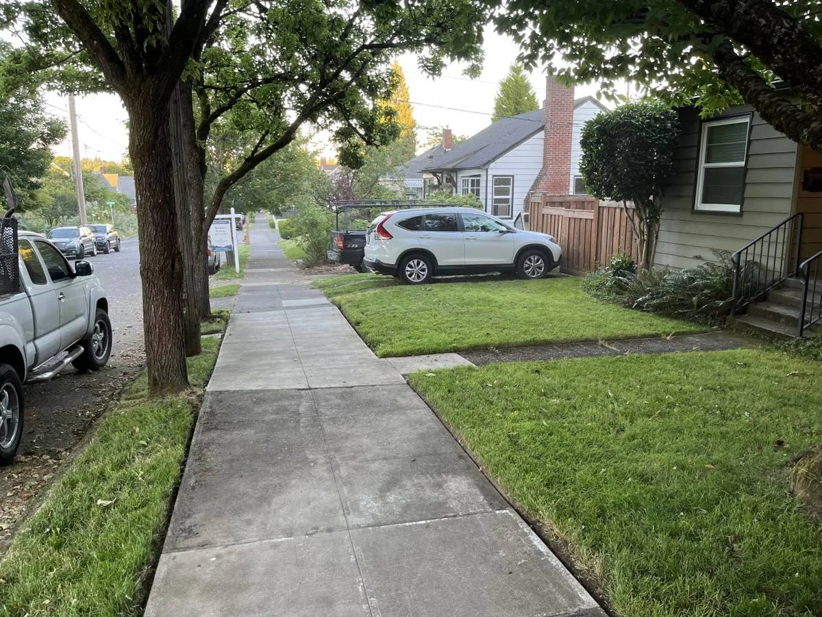 Freshly maintained front lawn with clean edges in front of a gray house